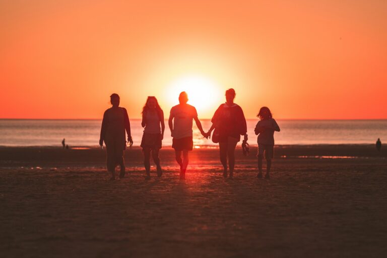 Silhouetten von 5 Menschen am Strand vor Sonnenaufgang