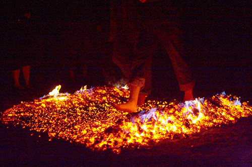 zwei Füße laufen über glühende Kohlen