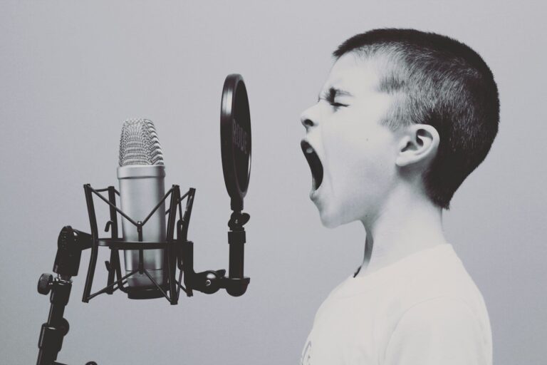 Junge singt laut vor Mikrofonen