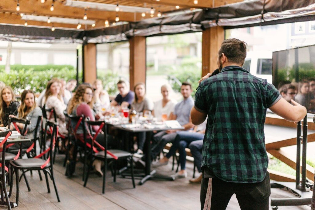 Redner vor Leuten am Tisch im Café